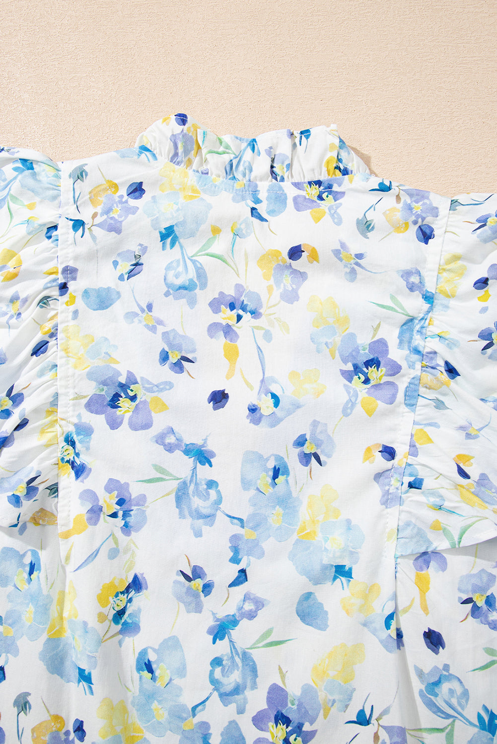 Sky blue floral print blouse by Modern Grace with frilled notched V-neck, made of cotton and viscose fabric.