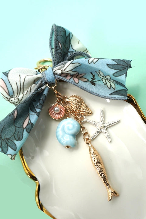 Ocean porcelain bag charm with fish, seashell, and starfish designs, by Modern Grace, perfect as a stylish accessory.