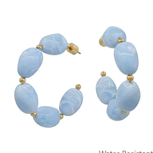 Water-resistant blue oval acrylic hoop earring, 2-inch jewelry piece with a shiny finish and smooth oval shape.