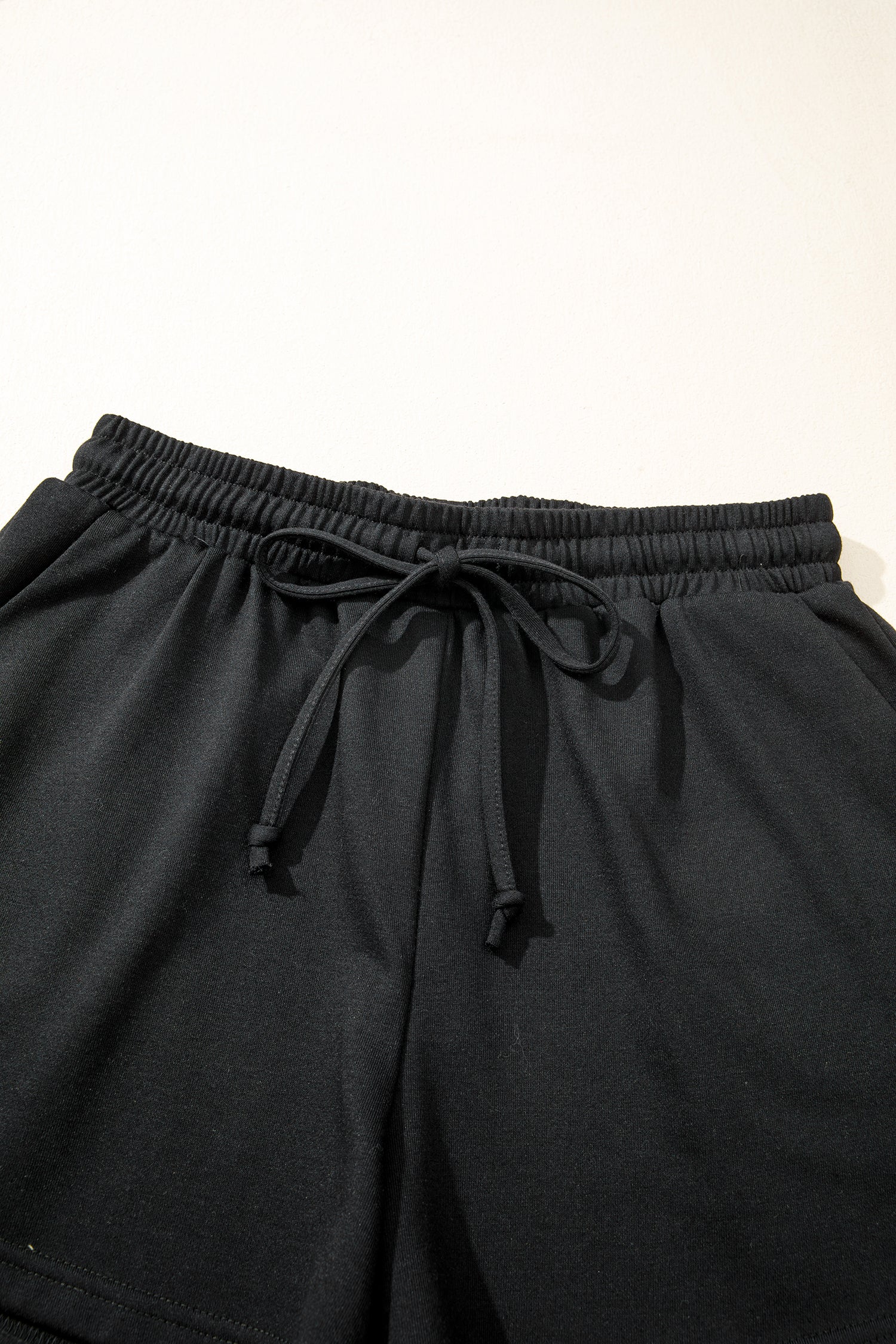 Modern Grace black leopard bow V-neck loose tee and drawstring shorts two-piece set, stylish casual loungewear ensemble.