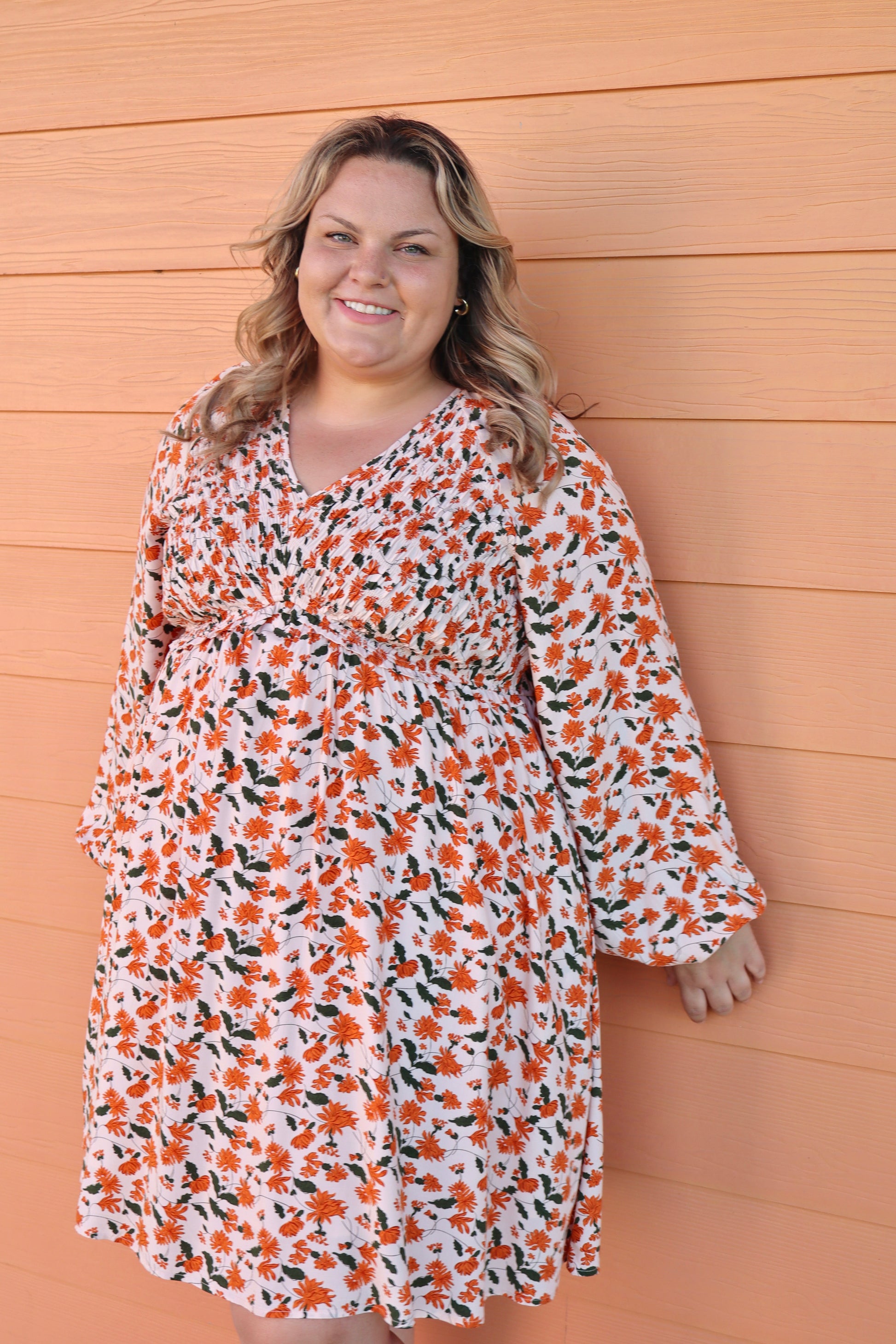 Modern Grace fall floral V-neck babydoll dress with long sleeves and smocked bust, featuring a flattering V-neck and flowing skirt.