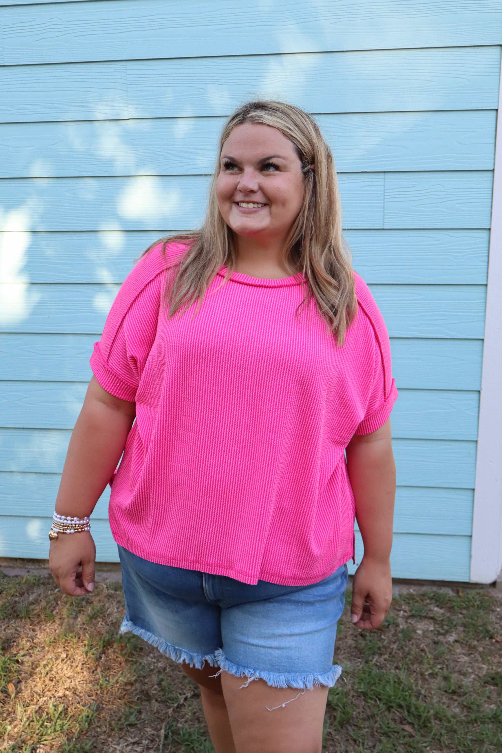 Modern Grace curvy hot pink ribbed cuff sleeve raw edge top with raised texture and casual style, shown on a model.