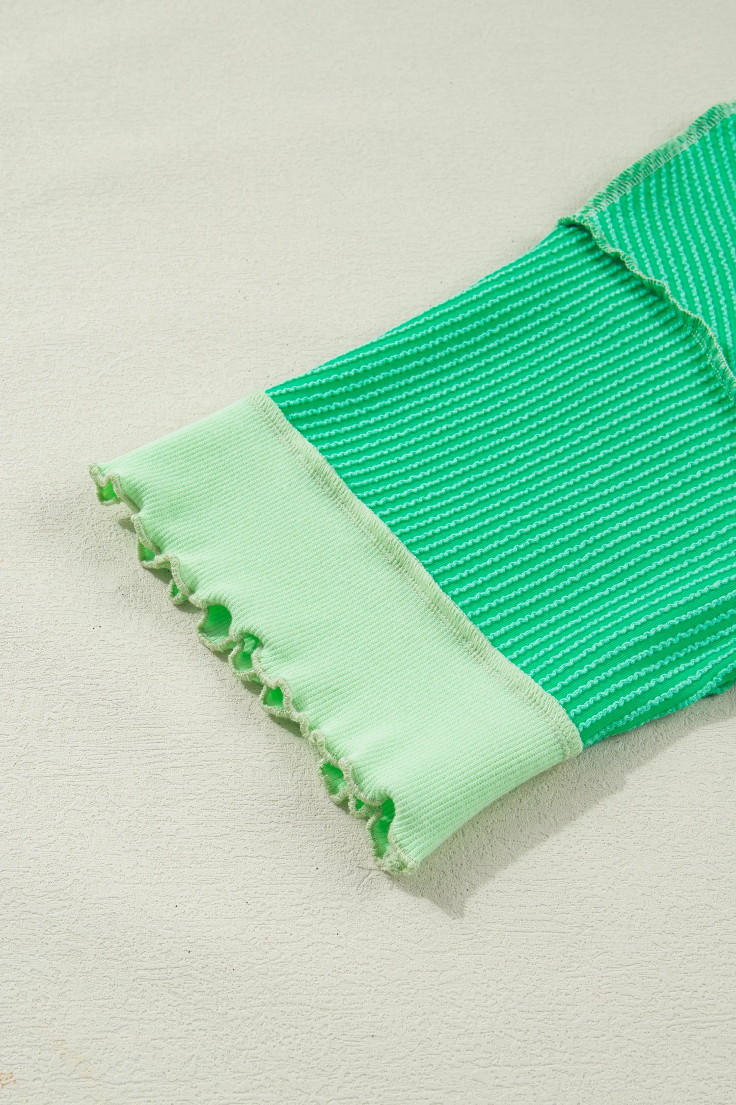 Mint green twisted rib knit tee with drop shoulder and uneven hem, styled as a modern Grace women's top.