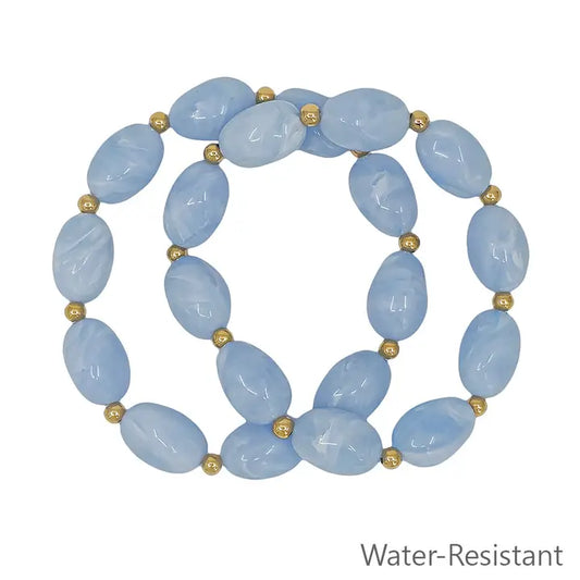 Set of 2 light blue oval acrylic and gold beaded stretch bracelets from What's Hot, featuring elegant jewelry design.
