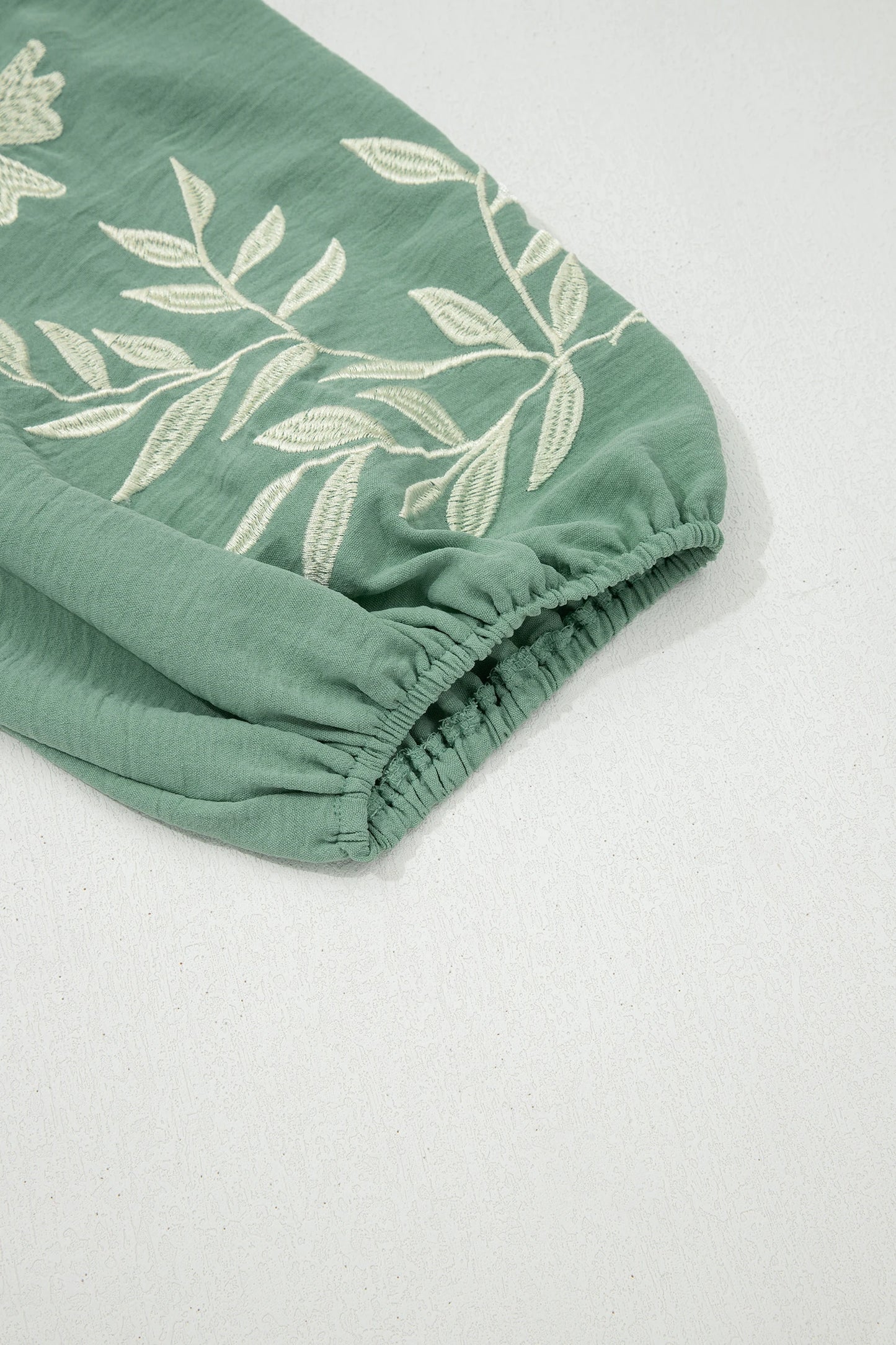 Sage green color block patchwork babydoll blouse with V-neck, embroidered details, and puff sleeves by Modern Grace