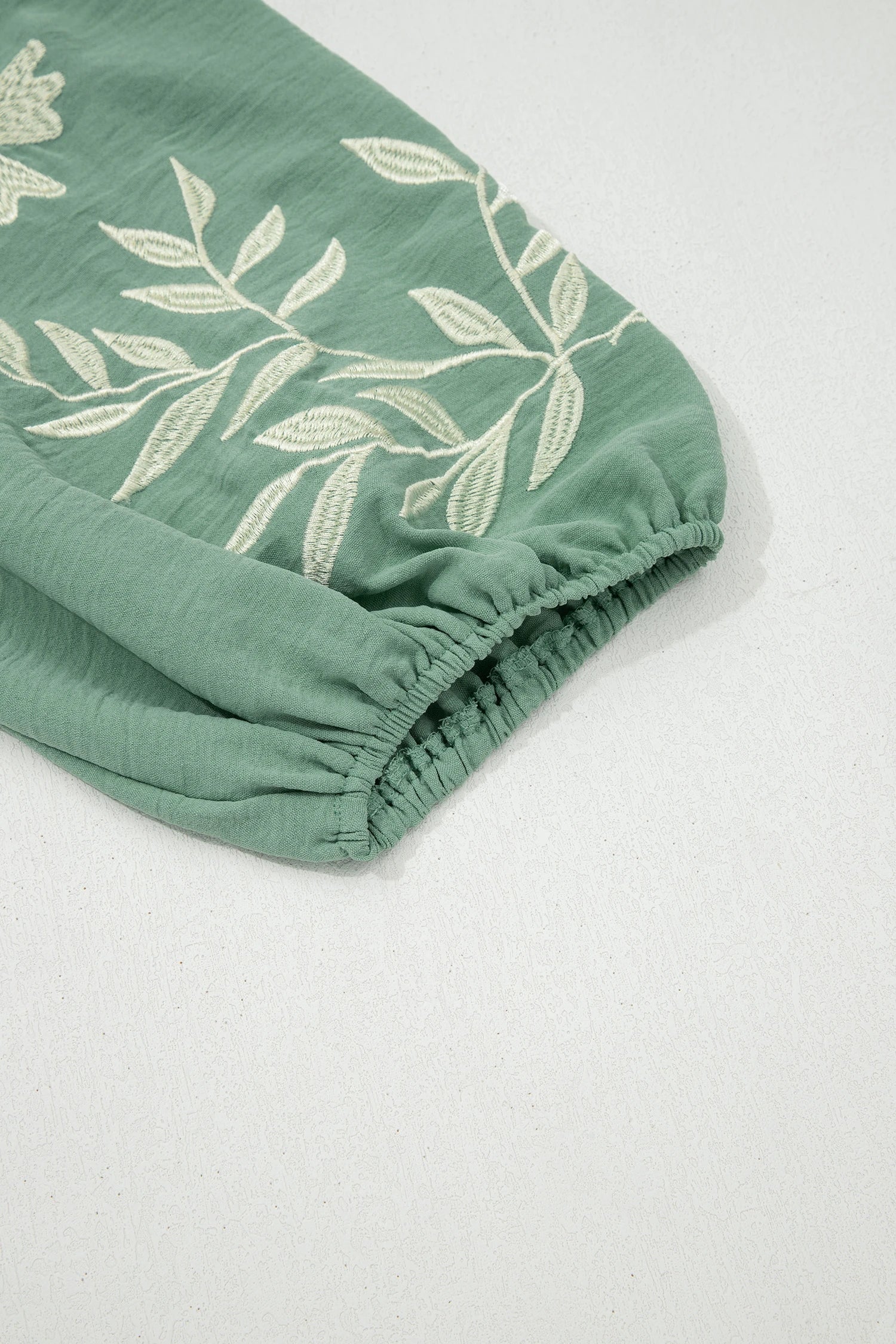 Sage green color block patchwork babydoll blouse with V-neck, embroidered details, and puff sleeves by Modern Grace