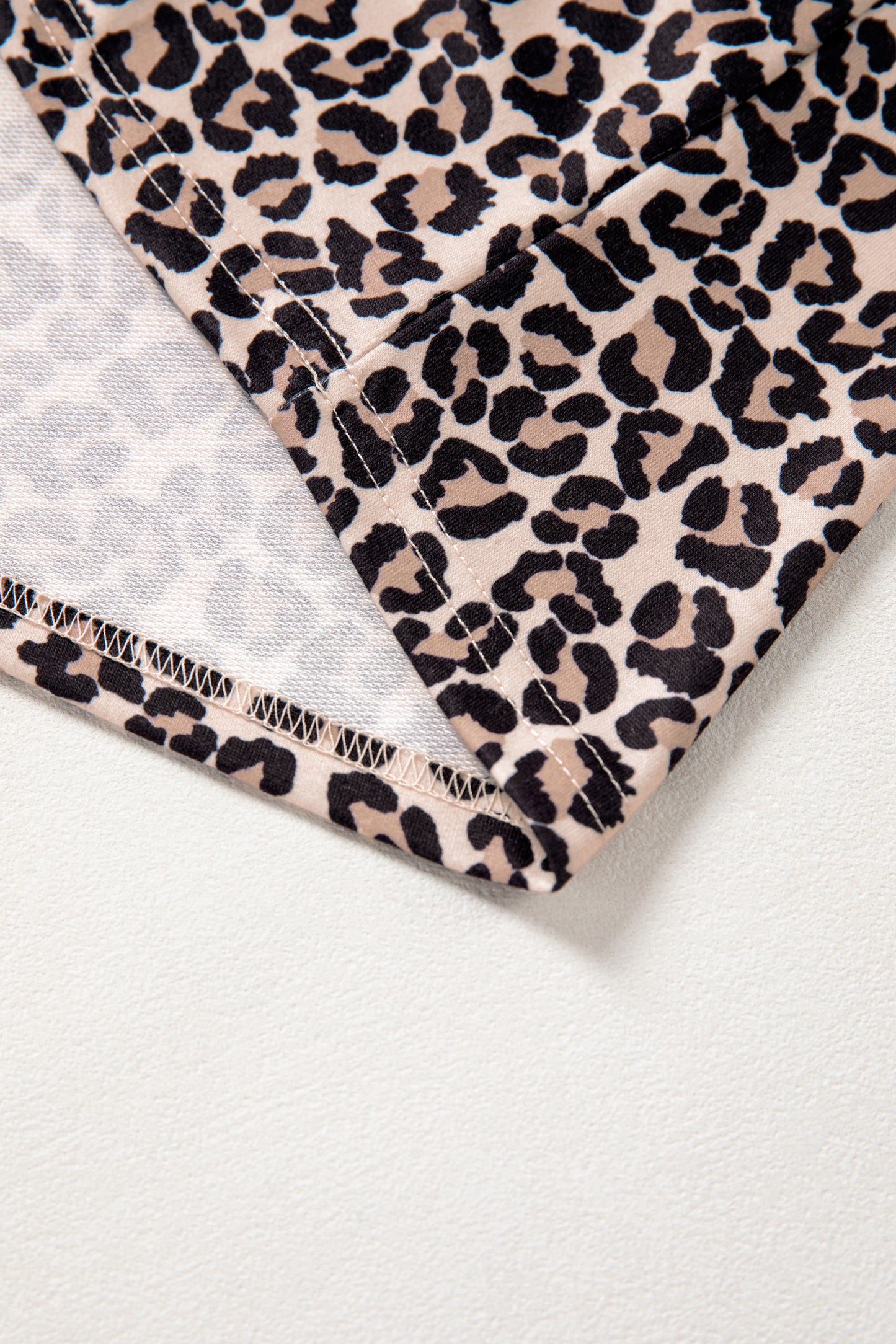 Brown leopard print half zip top by Modern Grace featuring striped trim and patchwork short sleeves.