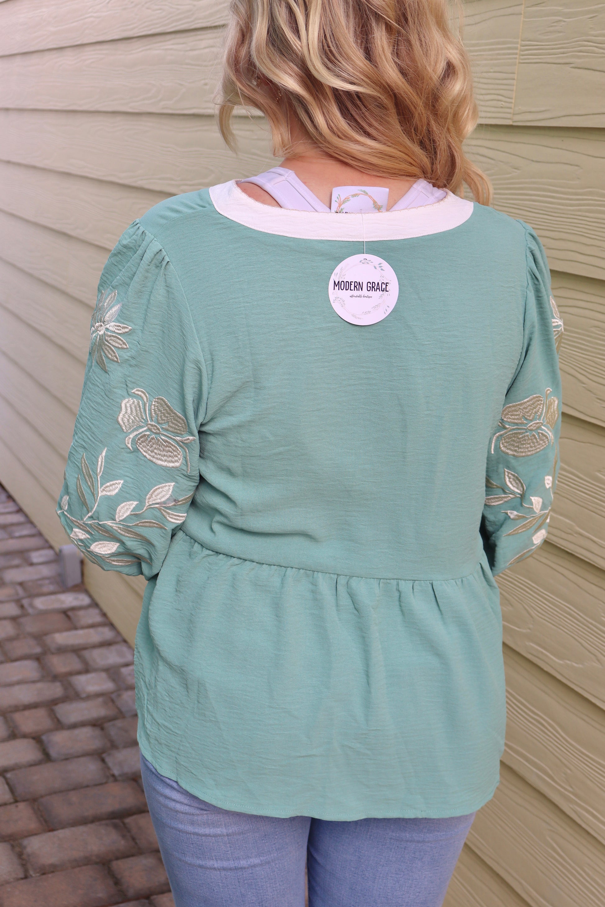 Sage green patchwork babydoll blouse with V-neck, embroidered details, puff sleeves, and color block design by Modern Grace
