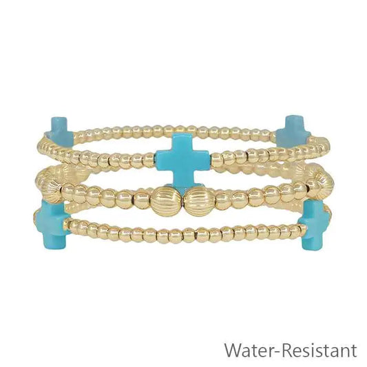 Set of three water-resistant gold beaded and turquoise-colored cross stretch bracelets by What's Hot, stylish jewelry accessories.