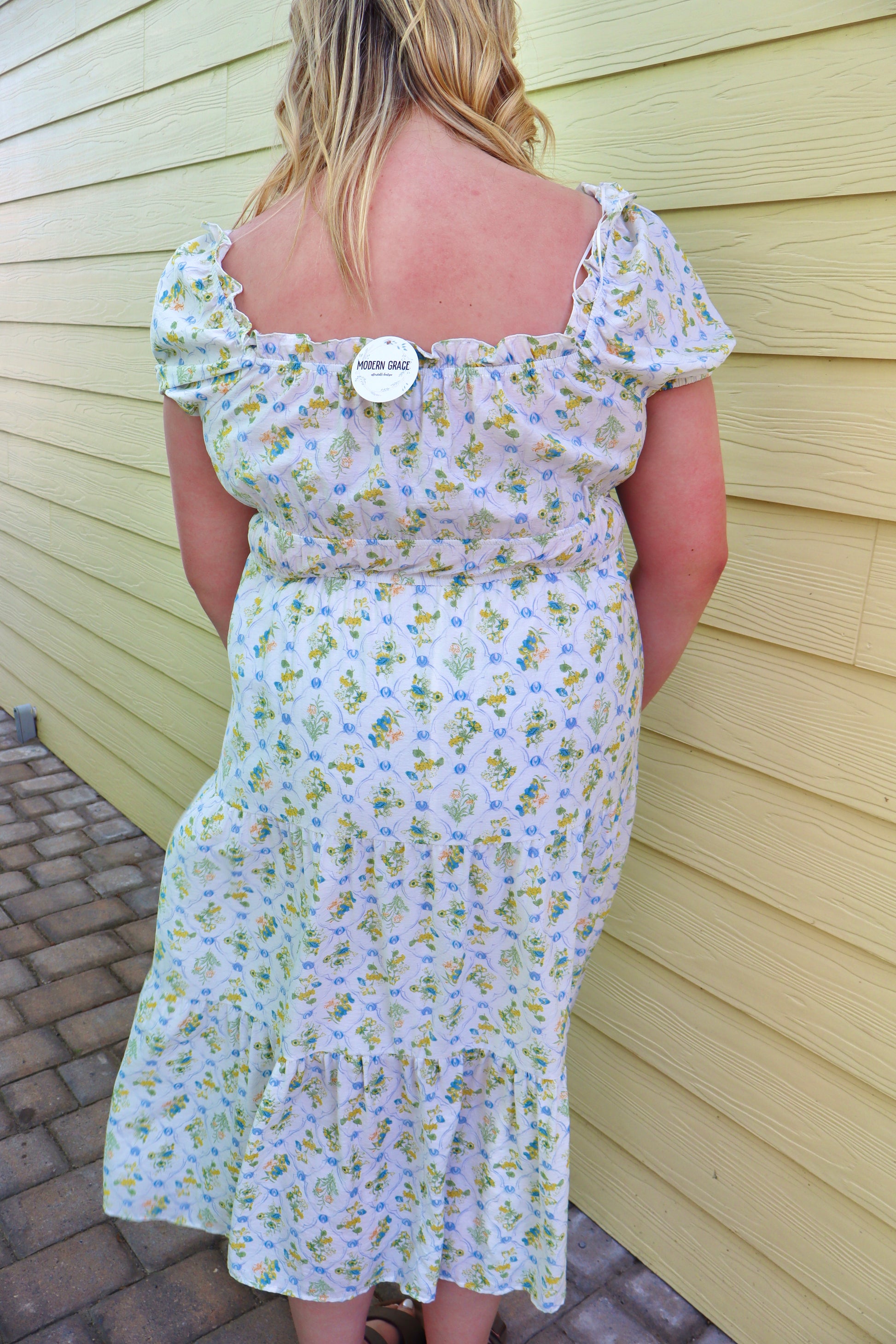 Blue floral tile print midi dress by Blu Pepper featuring contrast tie detail and a flattering silhouette.