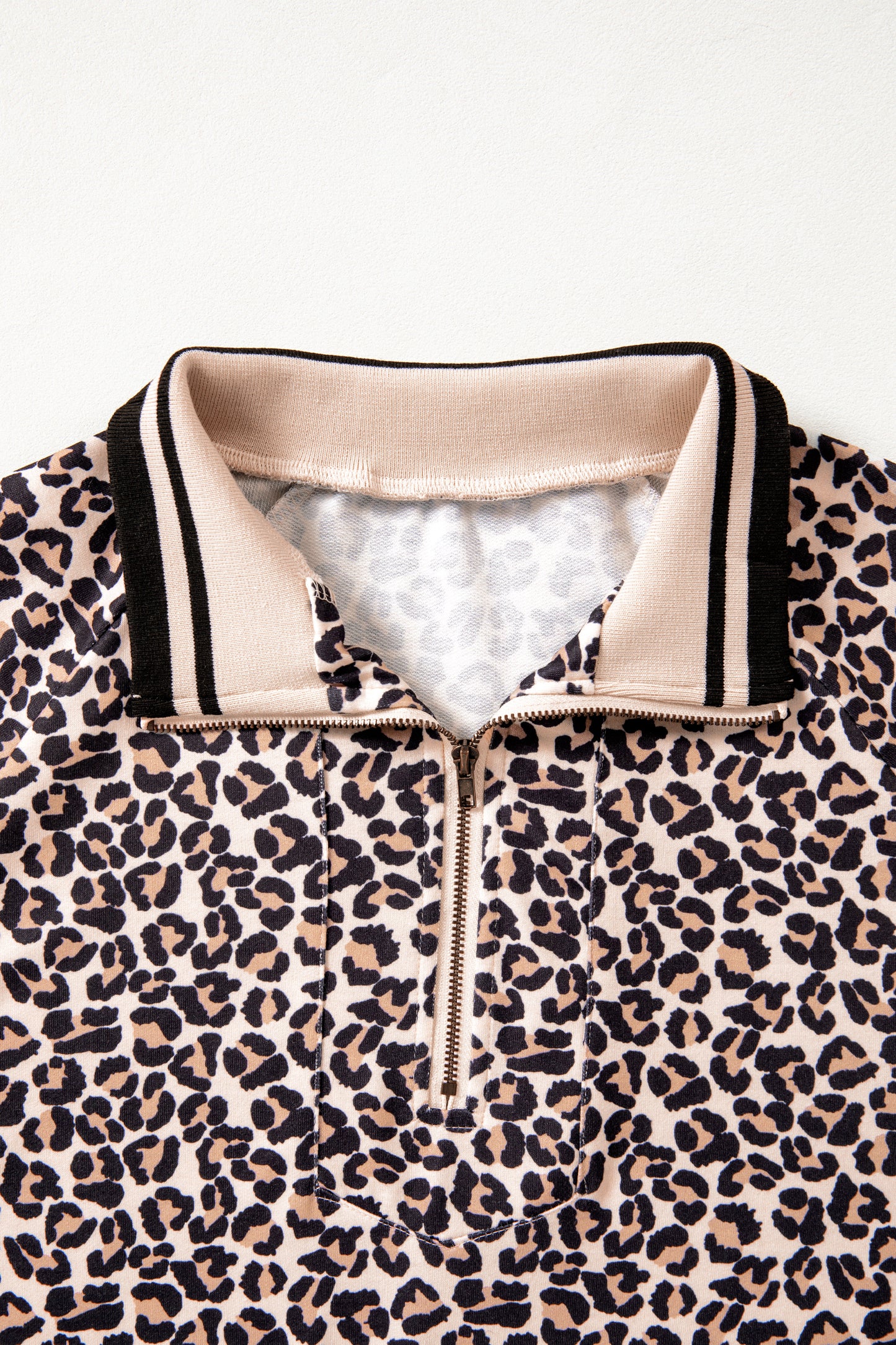 Brown leopard print half zip top by Modern Grace featuring striped trim, patchwork design, short sleeves, and a stylish casual look.