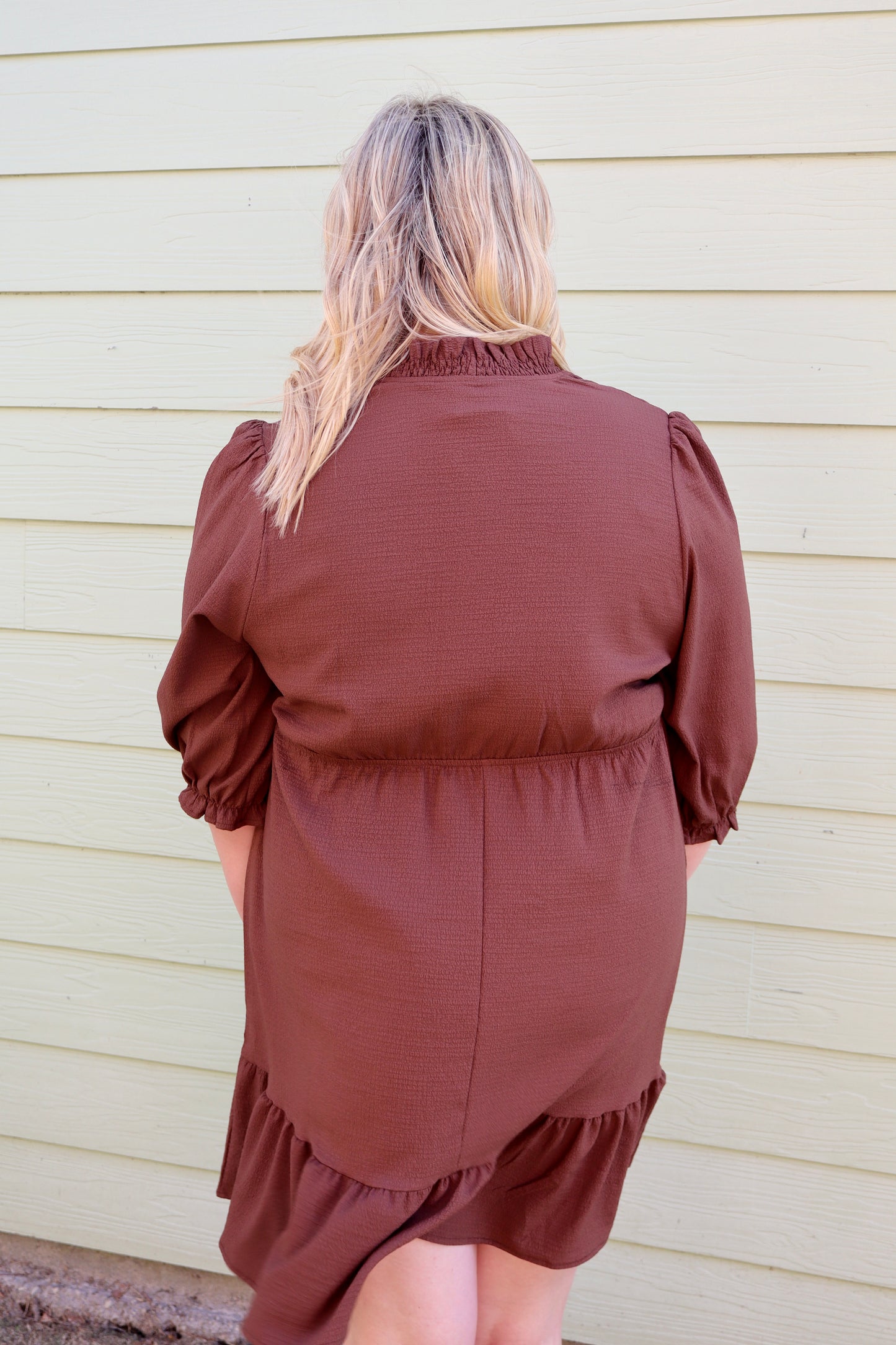 Brown textured dress with puff sleeves, V-neckline, and frilled trim by Modern Grace, showcasing a stylish, feminine design.
