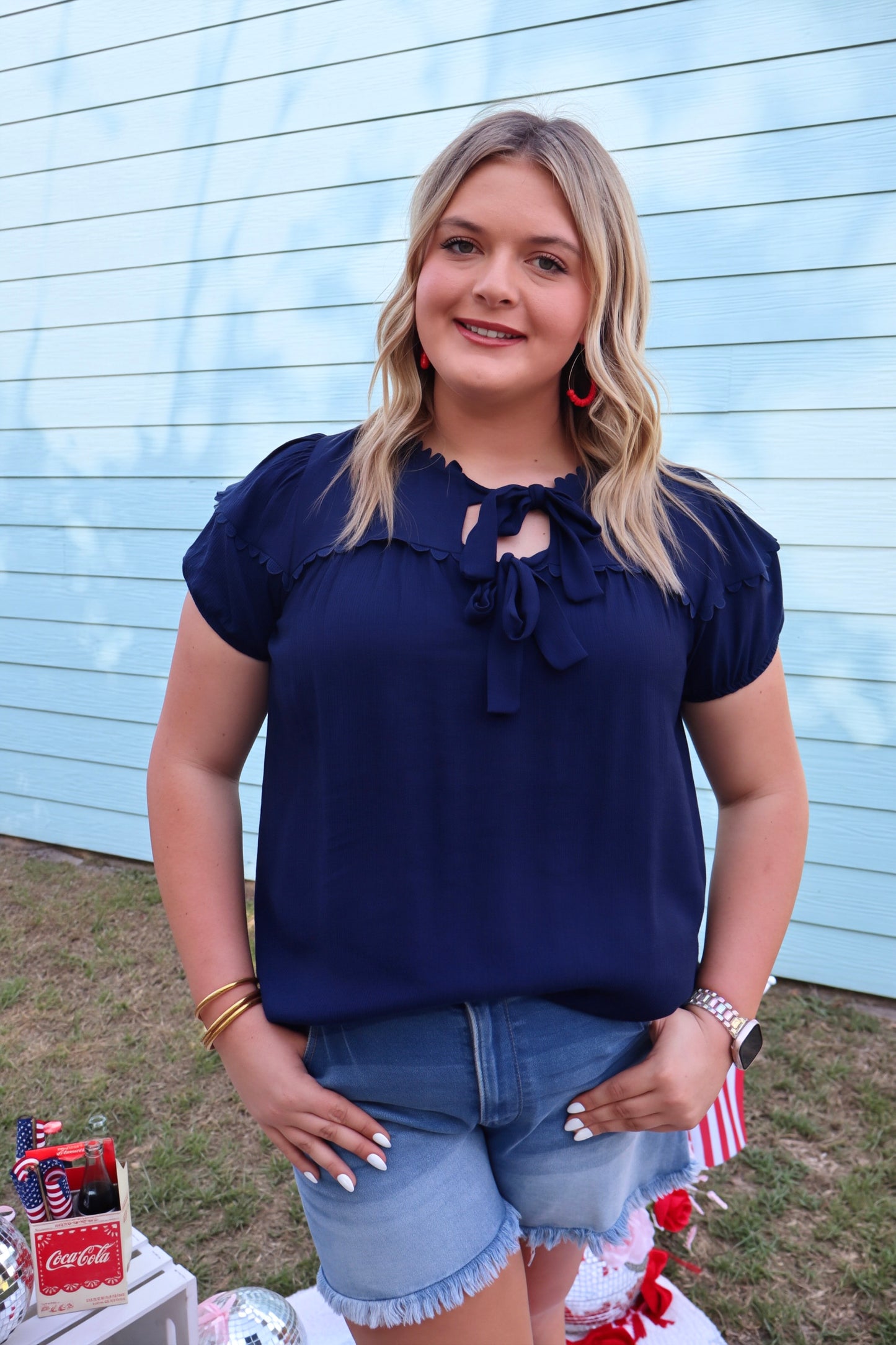 Navy blue scallop trim bow blouse by Modern Grace featuring a fitted silhouette and elegant design, styled with short sleeves.