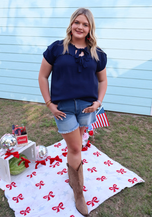 Navy blue scallop trim bow blouse by Modern Grace featuring a fitted silhouette and elegant design.
