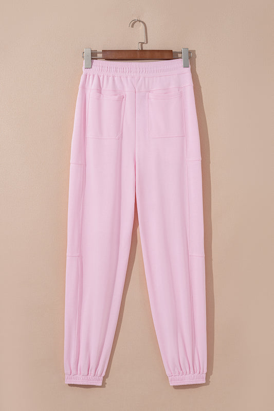 Light pink drawstring waist jogger pants by Modern Grace with patchwork design, solid color, and casual, comfortable fit.