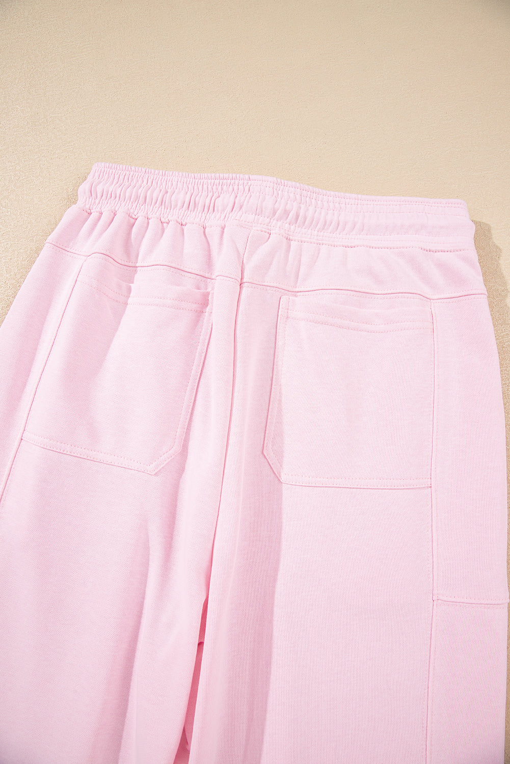 Light pink drawstring waist jogger pants by Modern Grace featuring patchwork design and solid color, made of cotton-polyester blend.