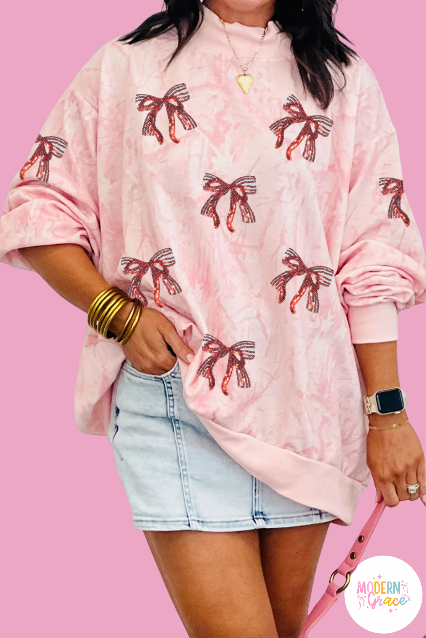 Pink tie-dye mock neck sweatshirt with sequin bow patch and baggy fit, by Modern Grace, featuring graphic design and casual style.