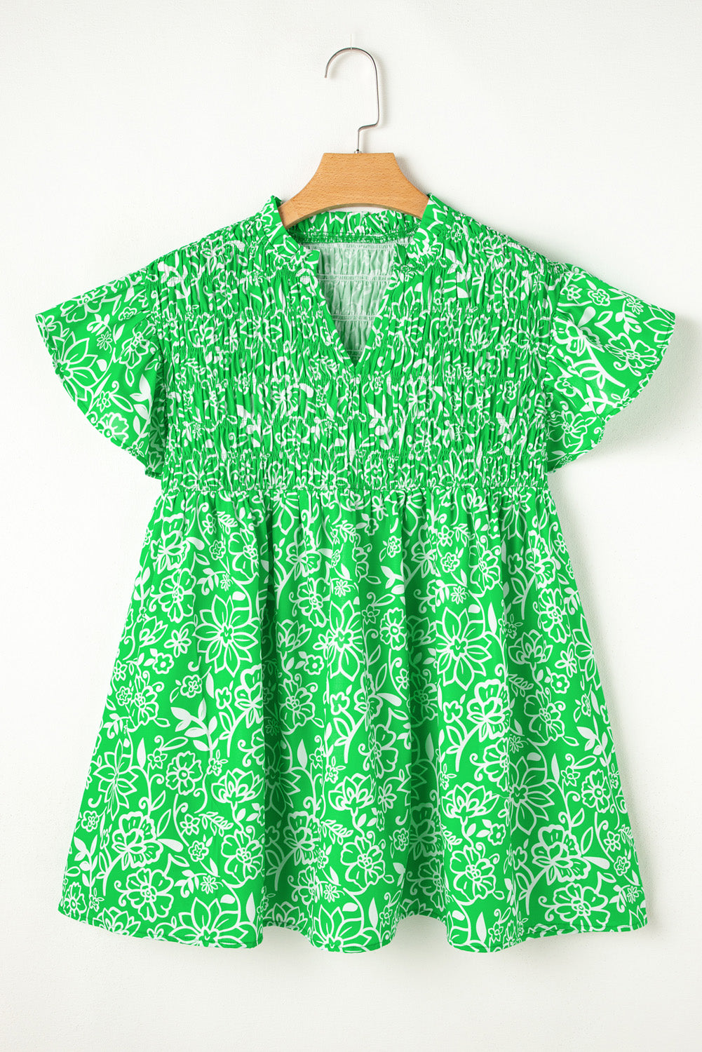 Green floral plus size blouse from Modern Grace with flutter sleeves, shirred details, and notched neckline, perfect for stylish comfort.