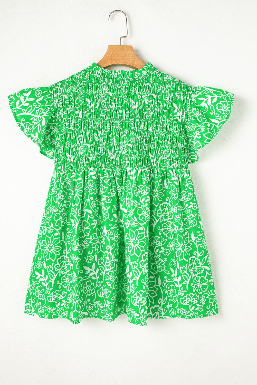 Green floral plus size blouse by Modern Grace with flutter sleeves, shirred details, and a notched neckline.