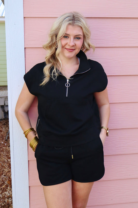 Black textured half zip top and drawstring shorts set by Modern Grace, featuring kangaroo pocket details and comfortable athletic style.