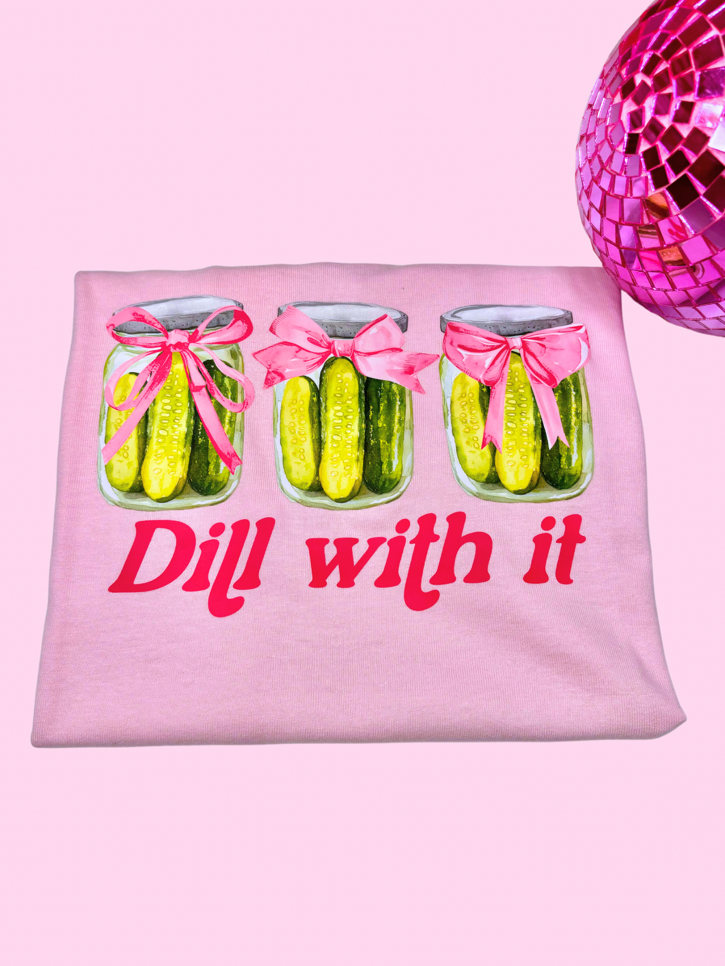 Pink T-shirt with "Dill With It" text from Modern Grace featuring a pickle graphic, casual and stylish for everyday wear.