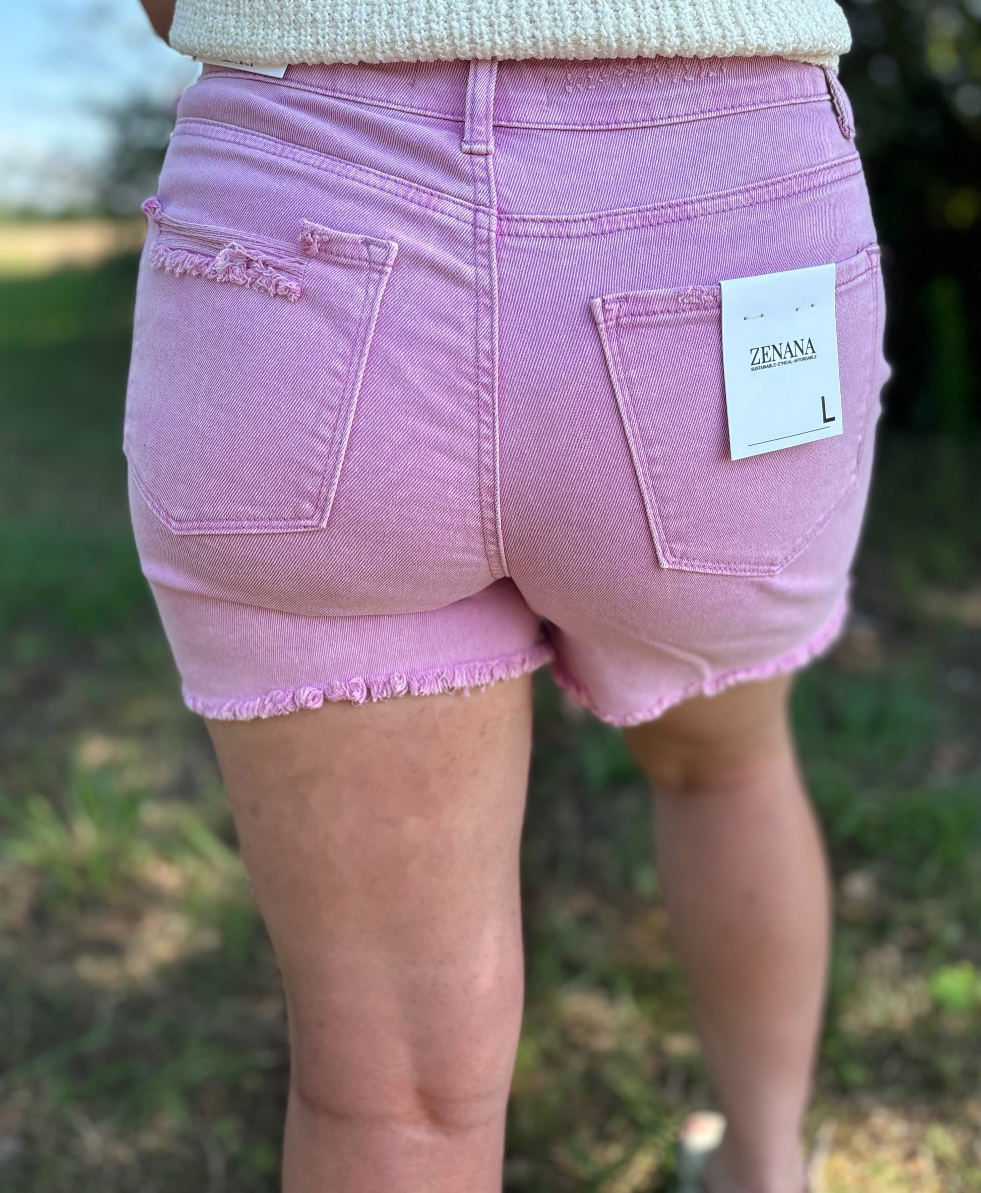 Mauve distressed raw hem shorts by Modern Grace, casual denim with frayed edges and a relaxed fit, suitable for warm weather.
