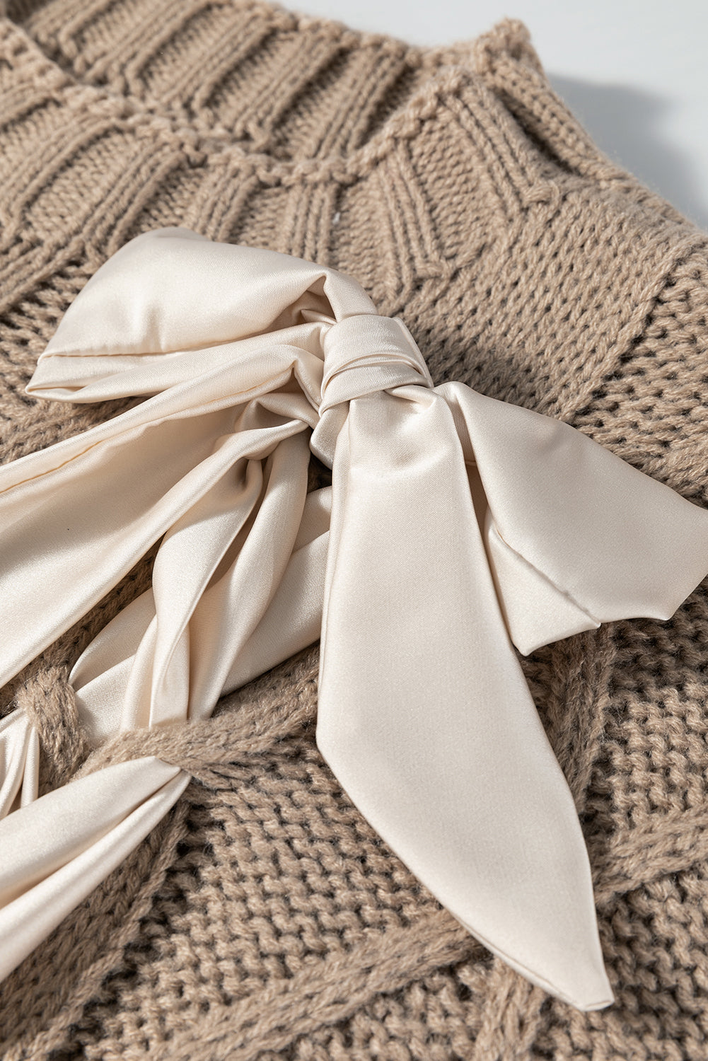 Modern Grace taupe cable knit short sleeve sweater with colorblock design and satin bowknot, made from 100% acrylic.
