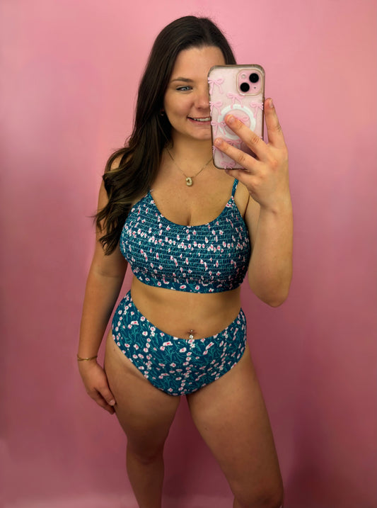 Blue floral print smocked bikini top from Modern Grace swimwear with adjustable straps and ruffled detailing.