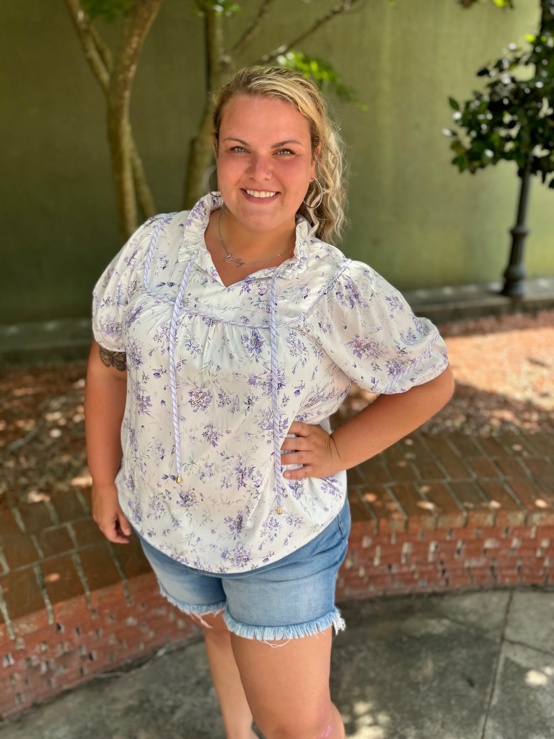 Curvy purple floral top by Modern Grace, featuring a stylish design with vibrant flower patterns on a comfortable fabric.