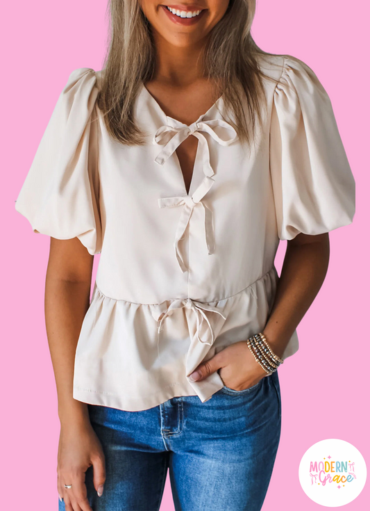 Off White Bow Tie Short Puff Sleeve Ruffle Hem Blouse by Modern Grace, lightweight polyester, stylish blouse with bow tie detail.