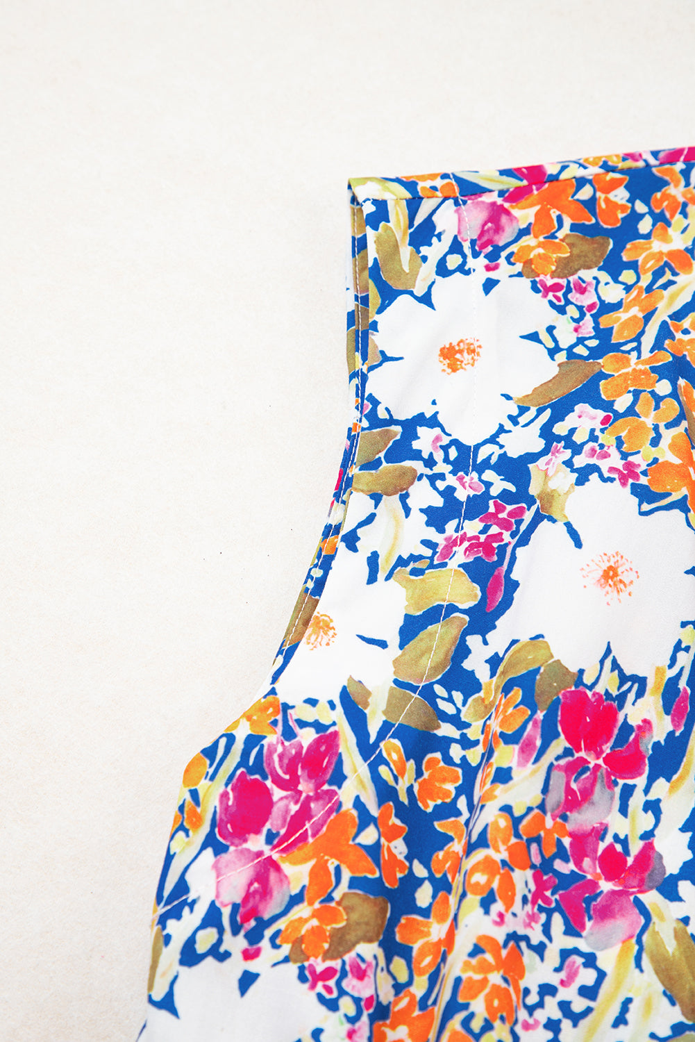 Modern Grace floral print sleeveless peplum blouse with bow appliqué, slit sleeves, and a feminine silhouette.