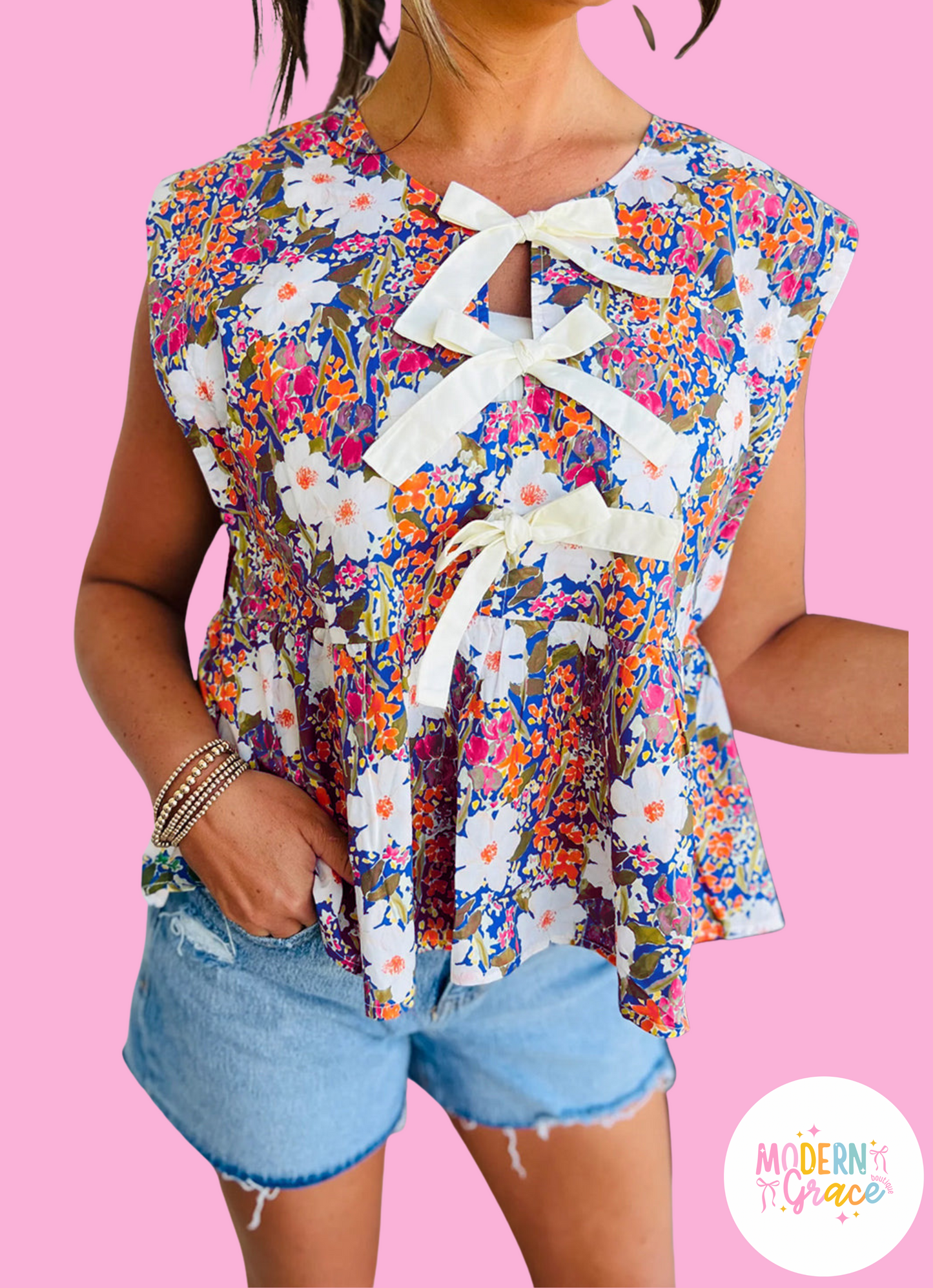Modern Grace floral print sleeveless peplum blouse with bow applique and slit sleeves, made of polyester, online exclusive.
