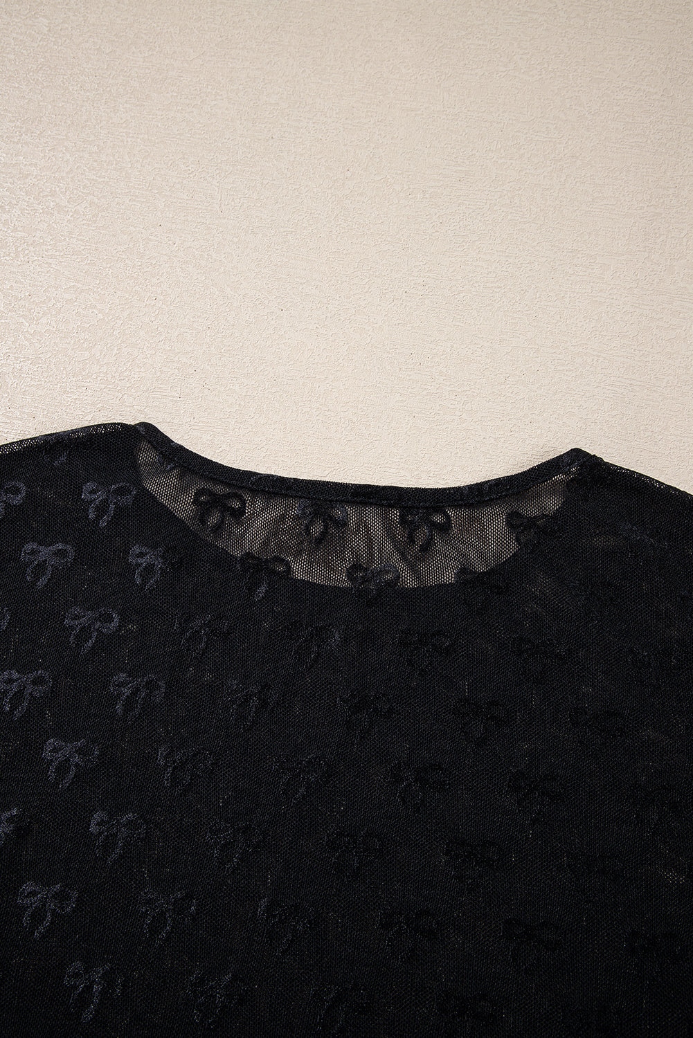 Black mesh long sleeve top with bow pattern by Modern Grace, featuring see-through fabric and fitted design.
