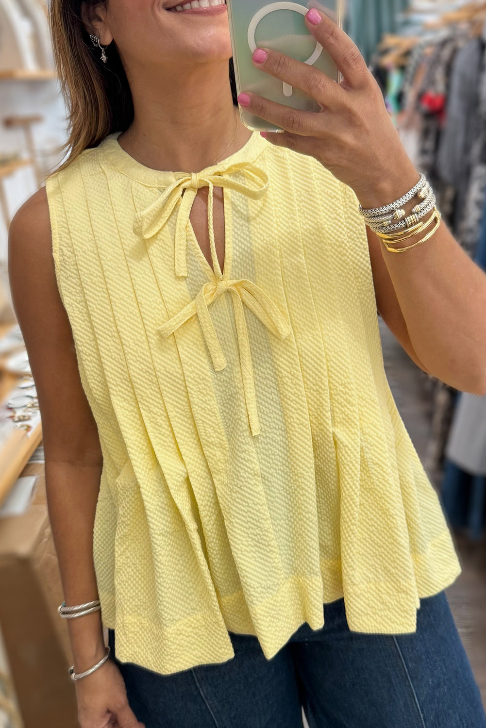 Yellow cream pleated tank top with bow tie and notched neckline by Modern Grace, featuring a sleeveless design and lightweight polyester fabric.