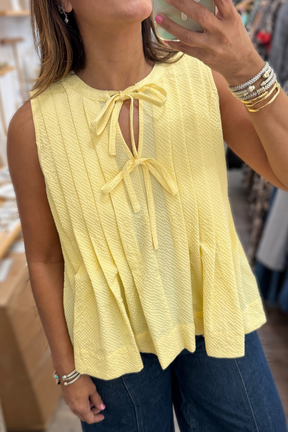Yellow cream bow tie tank top by Modern Grace featuring notched neck and pleated design, made of lightweight polyester fabric.