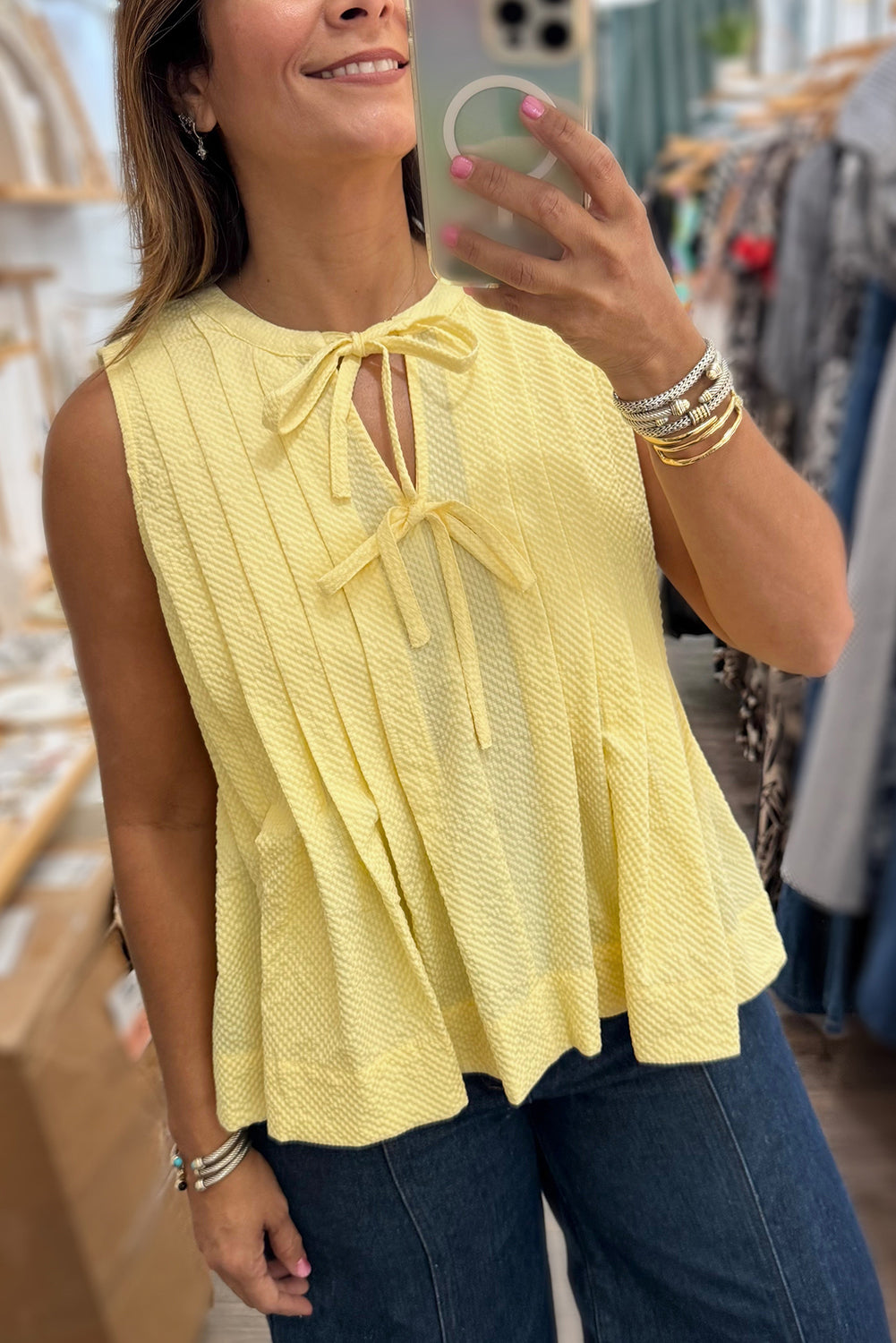 Yellow cream bow tie tank top by Modern Grace with notched neck and pleated design, made of lightweight polyester fabric.