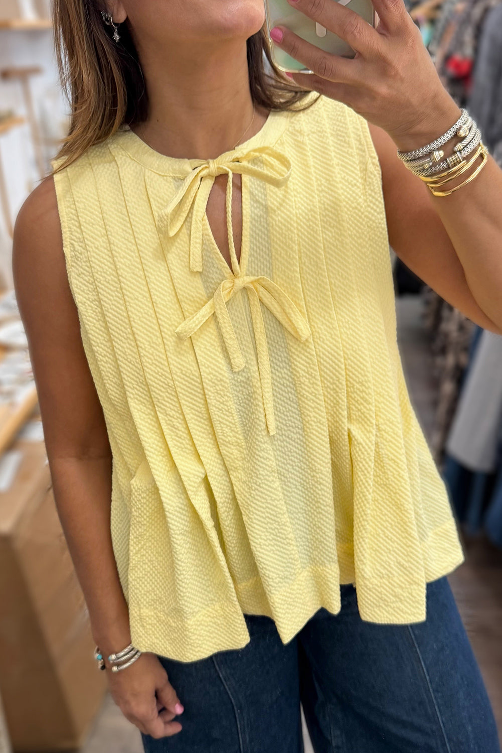 Yellow cream tank top by Modern Grace featuring a bow tie, notched neckline, and pleated design, made of lightweight polyester.