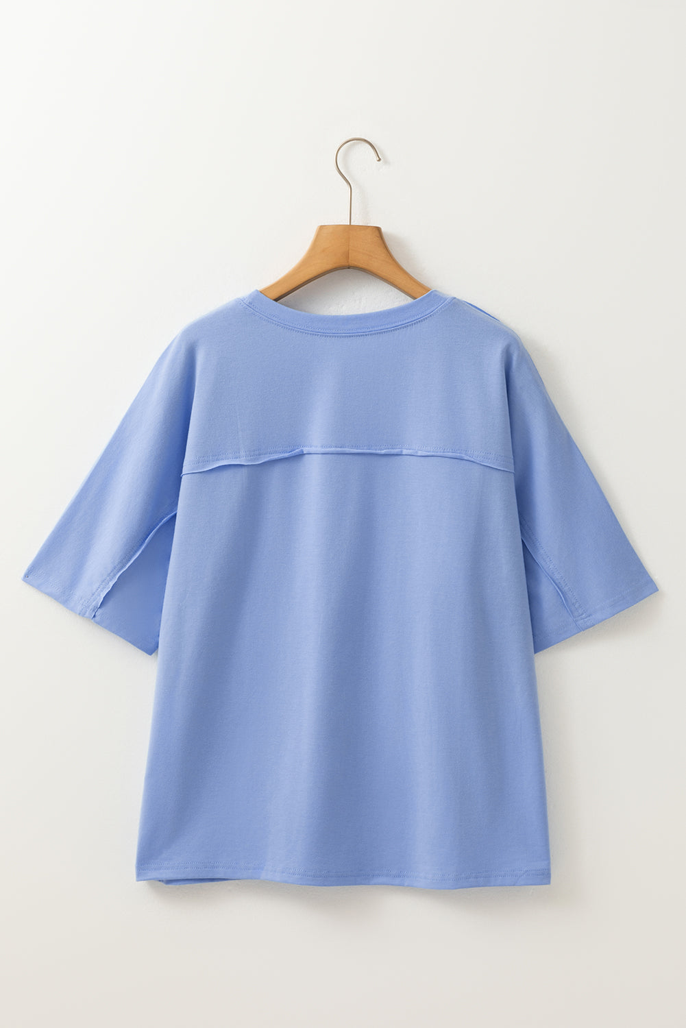 Sky blue crew neck loose tee by Modern Grace with flower patches, exposed stitching, and trim detailing, made from polyester, cotton, and elastane.