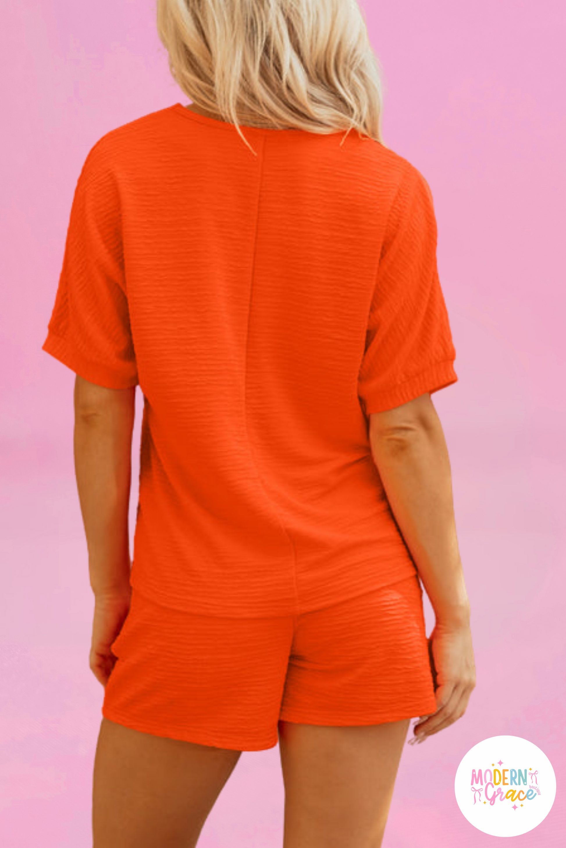 Orange textured V-neck T-shirt and shorts set by Modern Grace, made of polyester and elastane, displayed on a neutral background.