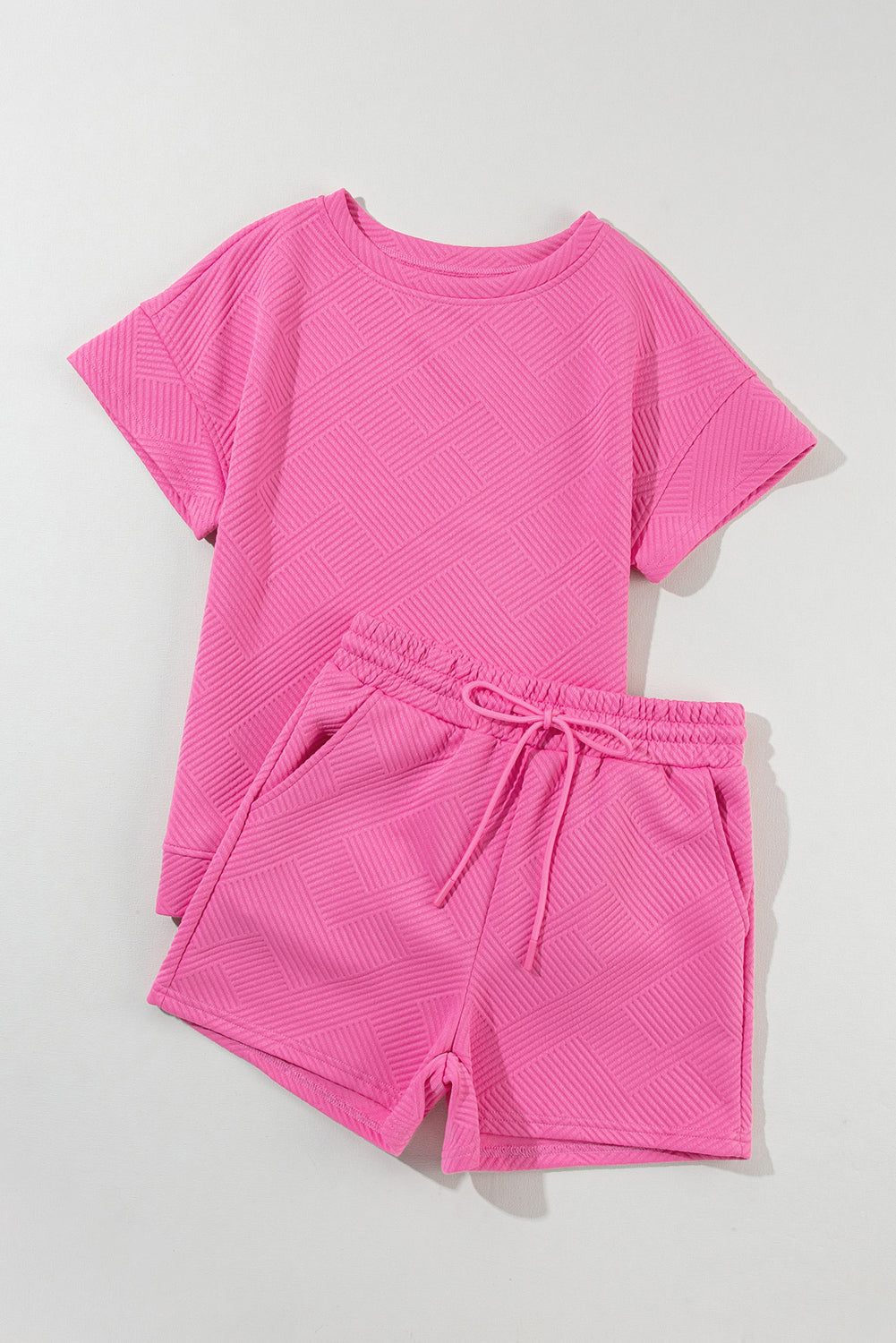 Modern Grace strawberry pink two-piece shorts set with textured drawstring shorts and matching top, made of polyester and elastane.