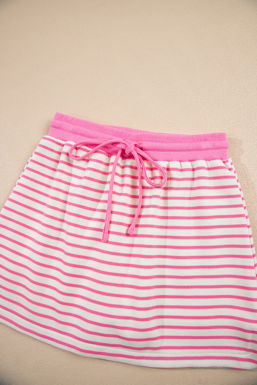 Modern Grace pink stripe two-piece outfit with collared V-neck pullover and matching skort, featuring drop shoulder design.