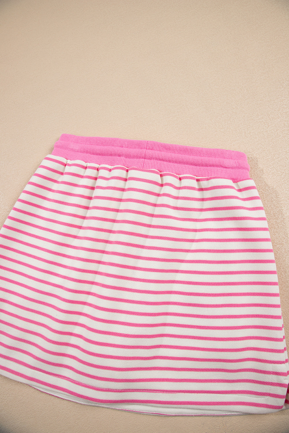Modern Grace pink stripe two-piece set with collared V-neck pullover and matching skort, featuring drop shoulder design.